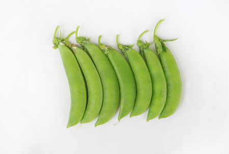 Fresh green peas against white background. Top view.