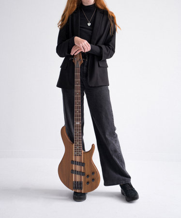 Red-haired girl with a bass guitar, in a black suit with a pendant