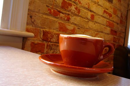 Cappuccino coffee on a saucer on tableの写真素材