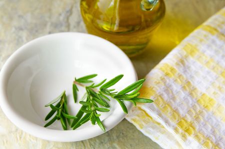 Fresh rosemary in a bowl, with olive oilの写真素材