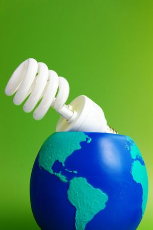 light bulb in an earth globe, on green backgroundの写真素材