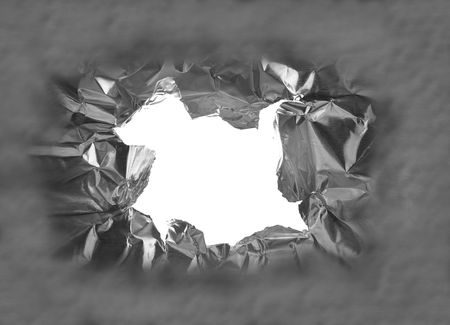 hole torn in a piece of metal, closeupの写真素材