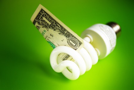 Compact fluorescent light bulb, with a dollar billの写真素材