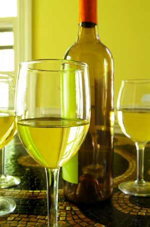 assorted glasses of white wine and bottleの写真素材