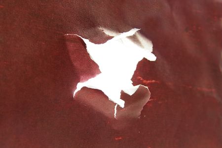 hole torn in red material,  side viewの写真素材