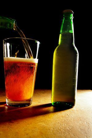 amber beer being poured into a pint glassの写真素材