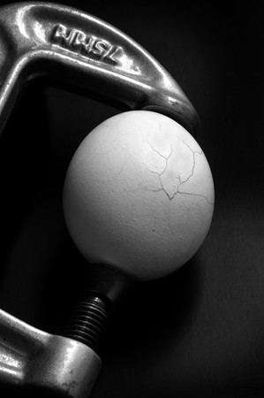 Egg in a vice cracking under pressureの写真素材