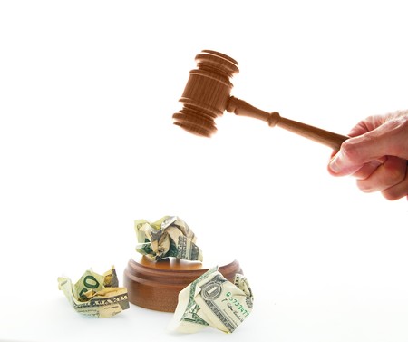 pounding a legal gavel on crumpled cashの写真素材