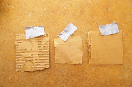 three pieces of torn grunge paper, taped to a wallの写真素材