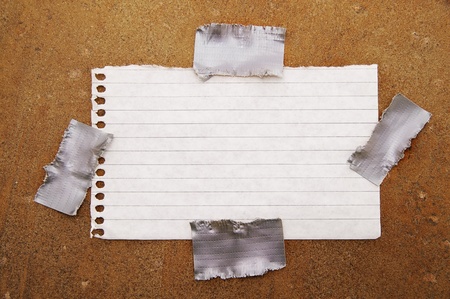 ripped piece of paper taped to grunge backgroundの写真素材