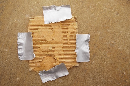 piece of ripped brown paper, taped to grunge backgroundの写真素材