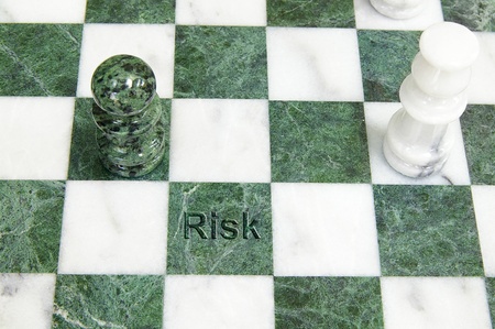 Chess pieces on the board with "risk" textの写真素材