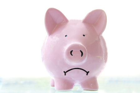 frowning pink piggy bank, on whiteの写真素材