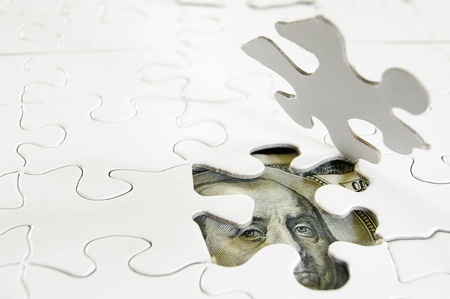 white puzzle pieces and US moneyの写真素材