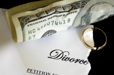 torn divorce decree and cash, with broken wedding ringの写真素材
