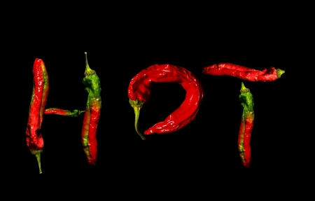 red hot spicy peppers, spelling  hot  on blackの写真素材