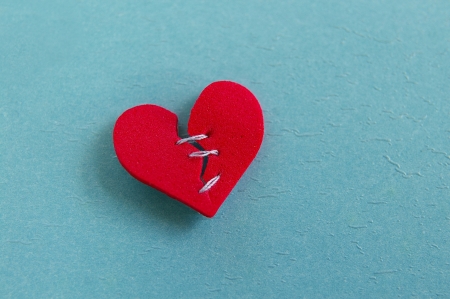 small red heart, broken with threaded stitchesの写真素材