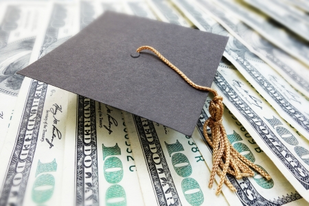 closeup of a mini graduation cap on cash                               の写真素材