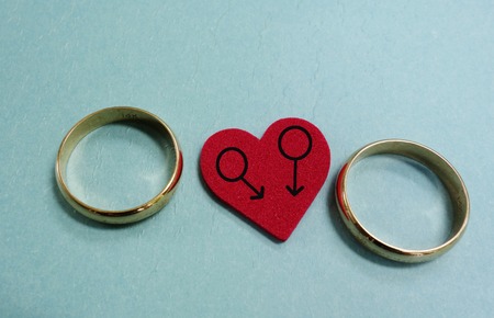 Two wedding rings and red heart with male gender symbols - gay marriage conceptの写真素材