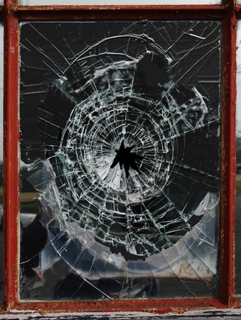 Shattered glass window pane with jagged holeの写真素材
