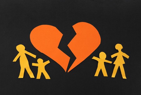 Paper family split apart with broken heart in the middleの写真素材