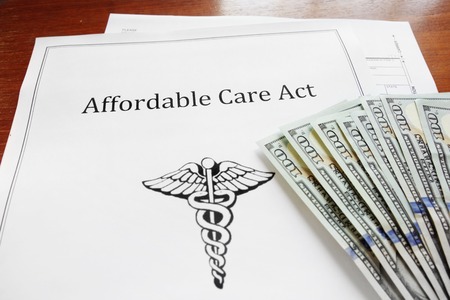 Affordable Care Act insurance papers with cashの写真素材