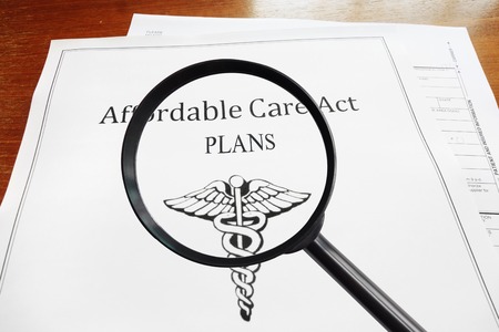 Affordable Care Act Plans document and magnifying glassの写真素材