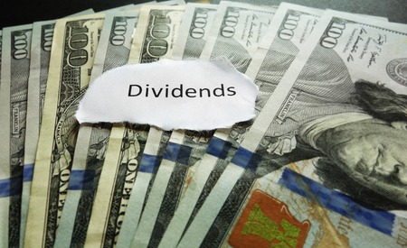 Closeup of hundred dollar bills with Dividends news headlineの写真素材