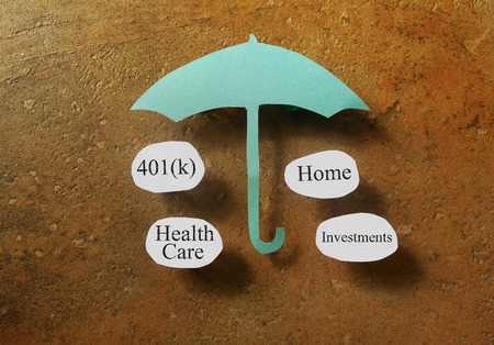 Retirement and investing terms under a paper umbrella - retirement planning conceptの写真素材