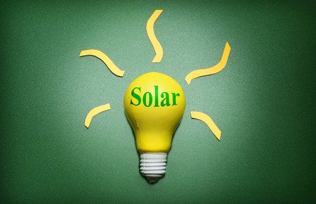 Solar light bulb on green - green energy conceptの写真素材