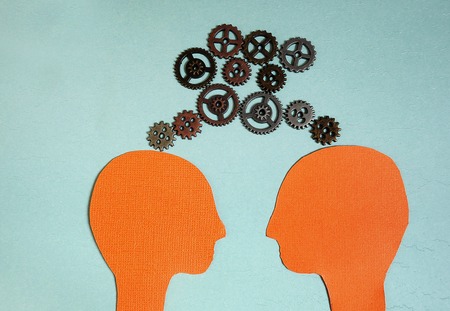 Two paper heads with metal gears - teamwork or sameness conceptの写真素材