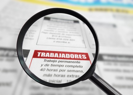 Employment section of a Spanish language newspaper with magnifying glassの写真素材