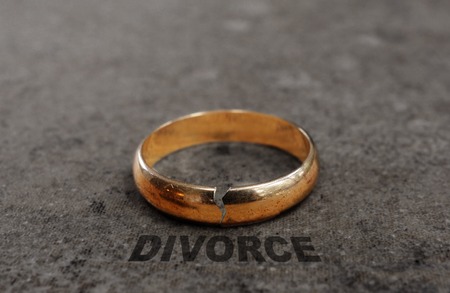 Cracked gold wedding ring with Divorce textの写真素材