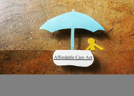 Paper person under Affordable Care Act umbrella - Obamacare conceptの写真素材