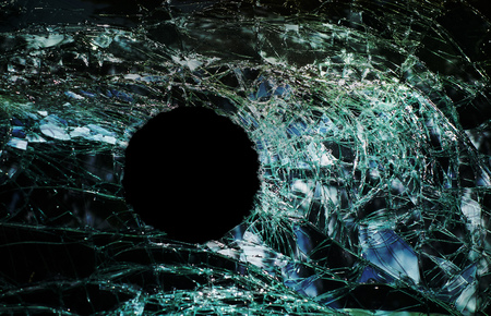 Bullet hole in cracked glass windowの写真素材
