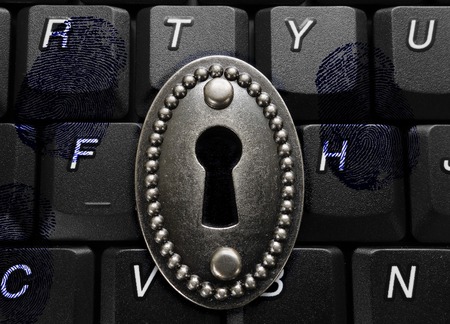 lock with keyhole on computer keyboard with fingerprints -- data security conceptの写真素材