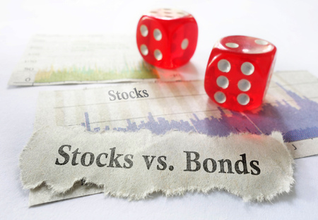 Stocks vs Bonds newspaper headline with dice and stock chartsの写真素材