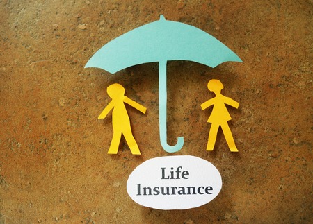 Paper couple under and umbrella with Life Insurance messageの写真素材