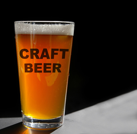 Pint glass of Craft Beer, backlit on blackの写真素材