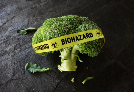 Yellow Biohazard tape on a piece of broccoli -- food safety conceptの写真素材