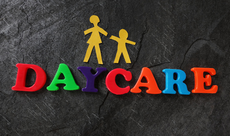 Daycare spelled out in play letters with paper mother and childの写真素材