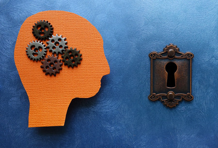 Gears and paper head cutout with lock, on blue textured background - problem solving concept                                の写真素材