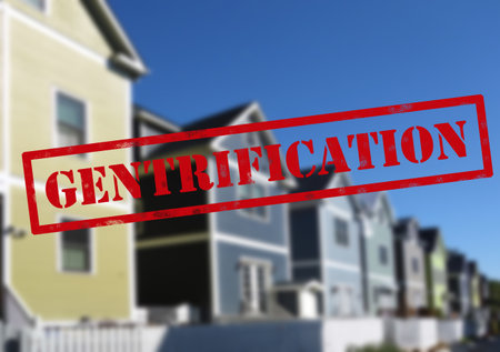 Red Gentrification text over new neighborhood homes in a cityのeditorial素材