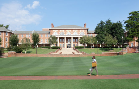 RALEIGH,NC/USA - 8-10-2020: A woman wearing a mask walks on campus at NC State University in Raleigh, NC after returning to classes for Fall semester during the Coronavirus pandemicのeditorial素材