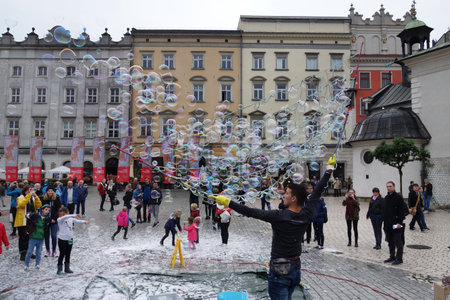 KRAKOW,POLAND - 9-22-2017: A street performer entertains the crowd with bubbles in the main square of Krakow Polandのeditorial素材