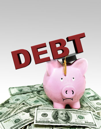 Frowning piggy bank under Debt text with graduation cap, on a pile of moneyの写真素材