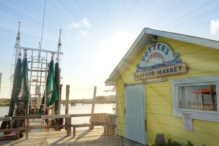 SOUTHPORT,NC/USA - 06-29-2021: Potters Seafood Market and fishing boat on the Cape Fear River in Southportのeditorial素材