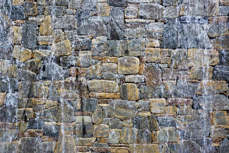 Water falling down a rock wall of a stone water featureの写真素材