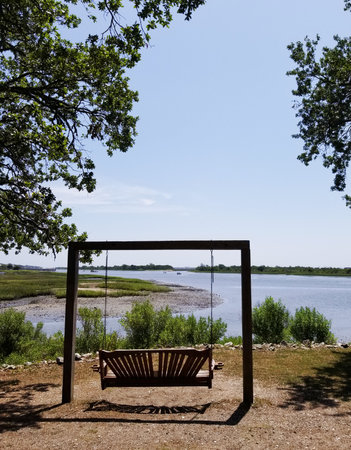 A swing overlooking the waterfront city park in Sunset Beach, North Carolinaの写真素材