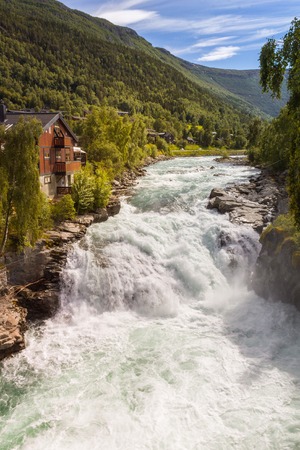 Waterfall, mountains and house in Lom, Norwayの写真素材